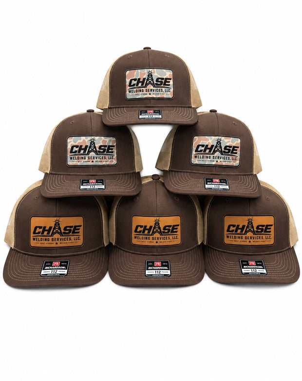 Six brown Chase Welding custom patch hats